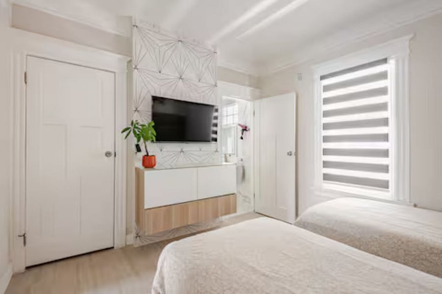 Bedroom #2 - 2 twin beds (Not bunks): The stunning abstract geometric TV wall design, with the smart TV enhancing both style and entertainment. The floating dresser, elegantly mounted on the accent wall, maximizes space while adding a sleek touch.