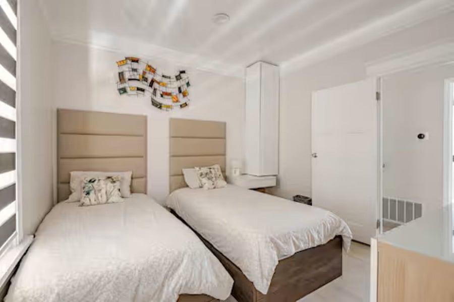 Bedroom #2 - 2 twin beds (Not bunks): Luxury leather-cushioned panels elevate the bedroom and living spaces, while the premium mattress ensures a restful night's sleep. The wall-mounted abstract artwork adds a dynamic visual touch, enhancing the overall guest experience.