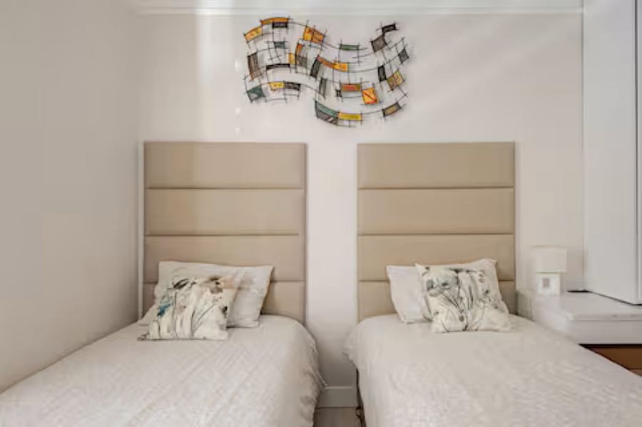 Bedroom #2 - 2 twin beds (Not bunks): Luxury leather-cushioned panels elevate the bedroom and living spaces, while the premium mattress ensures a restful night's sleep. The wall-mounted abstract artwork adds a dynamic visual touch, enhancing the overall guest experience.