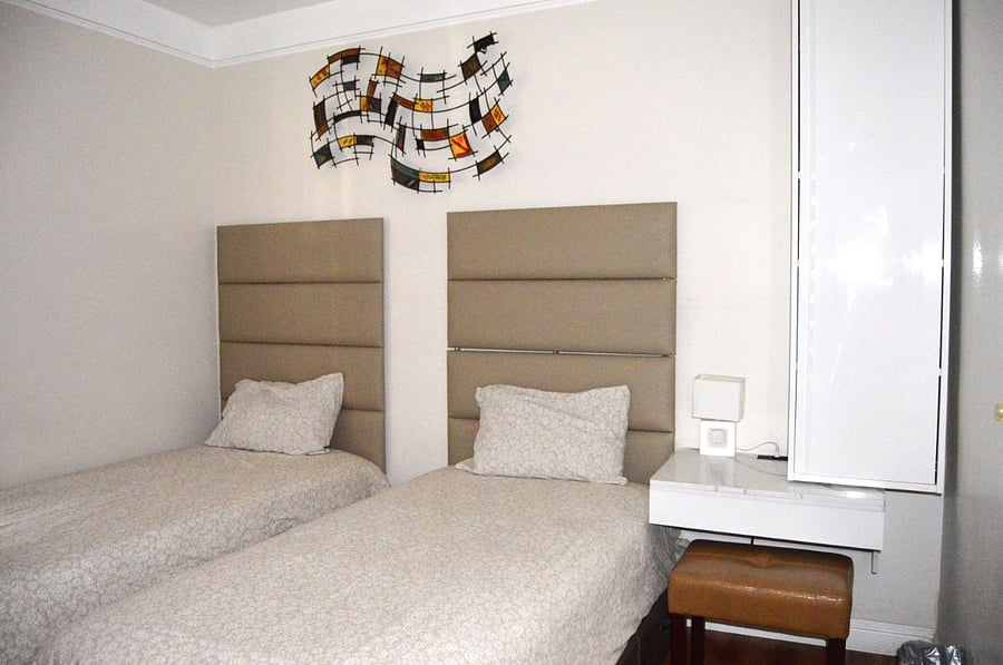 Bedroom #2 - 2 twin beds (Not bunks): Luxury leather-cushioned wall panels elevate the space, while a premium mattress ensures a restful nights sleep. Wall-mounted abstract artwork adds a dynamic visual touch, enhancing the overall guest experience. A floating desk provides a dedicated workspace for your laptop, paired with a comfortable stool.