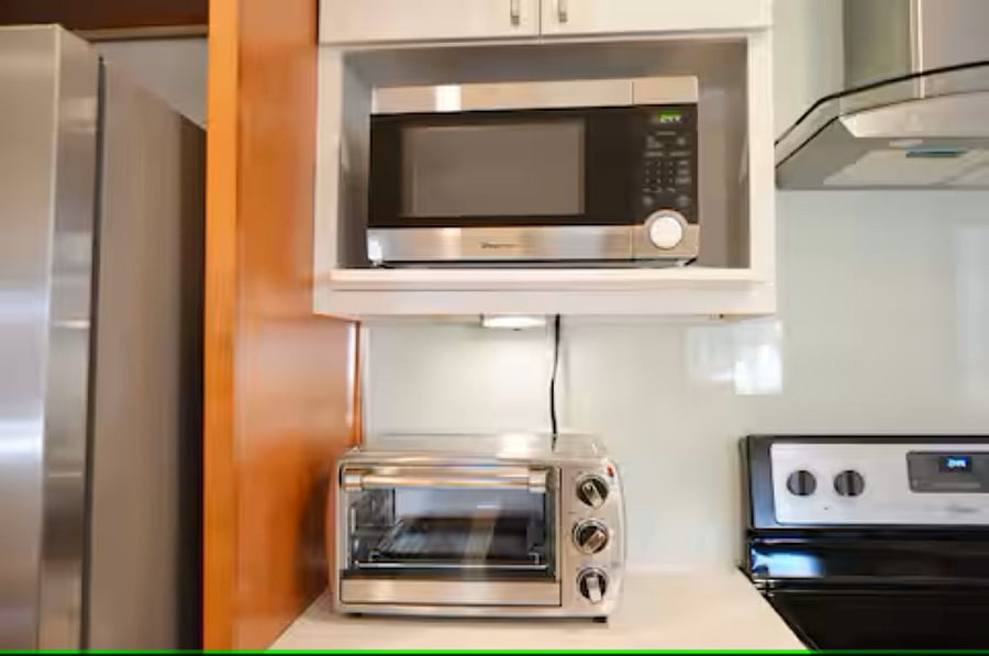 Kitchen: The kitchen corner includes a microwave and a compact toaster oven, ideal for preparing breakfast, snacks, or light meals with ease.