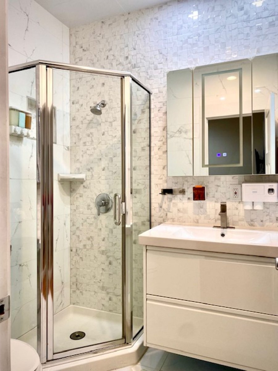 Bath #1: Fully tiled from floor to ceiling for a dust-free and mold-resistant environment. Upgraded with a towel warmer, automatic hand soap dispenser, and a floating vanity with the integrated sink to enhance both modern aesthetics and functionality