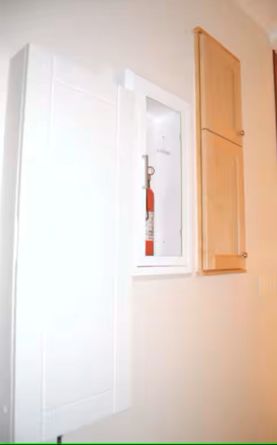 Hallway It features a wall-mounted fire extinguisher cabinet for easy emergency access and a built-in ironing board, offering a convenient, space-saving solution for laundry care