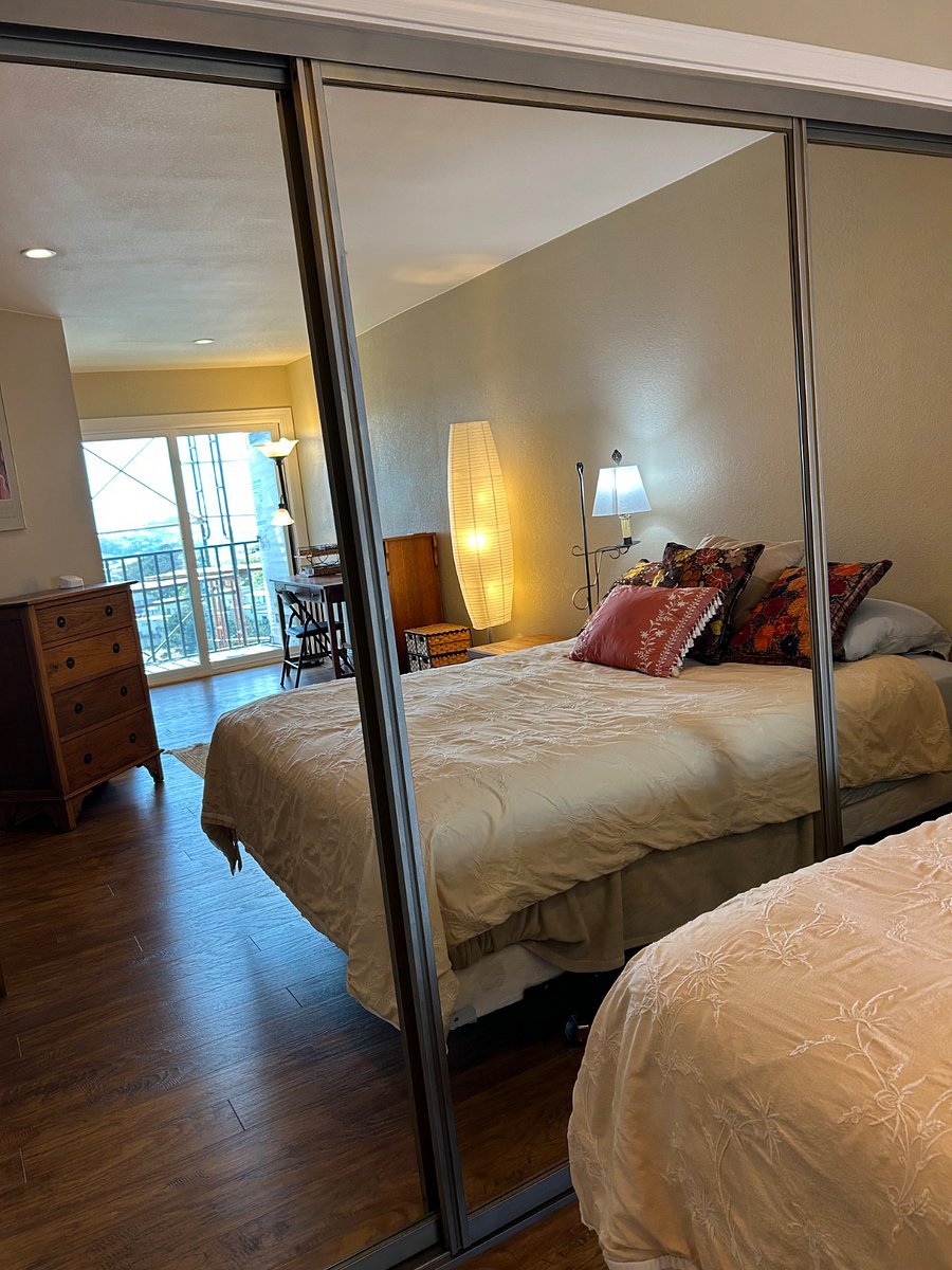 Closet with floor to ceiling mirrors reflecting the bedroom.