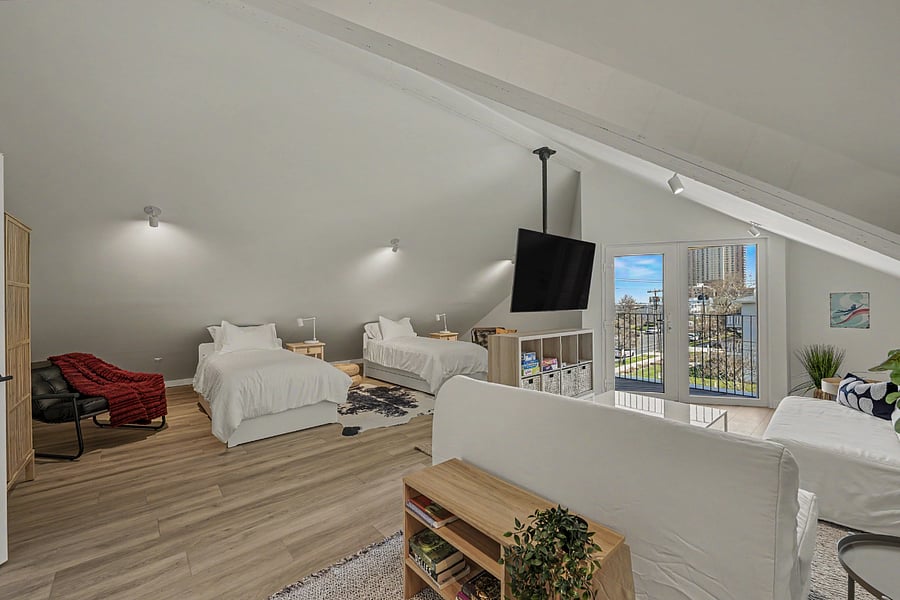 The top-floor loft. Another bed, a sleeper, a TV plus a small balcony. Used as teen bunker, overflow for a visiting couple, or the only quiet room on a summer Saturday.