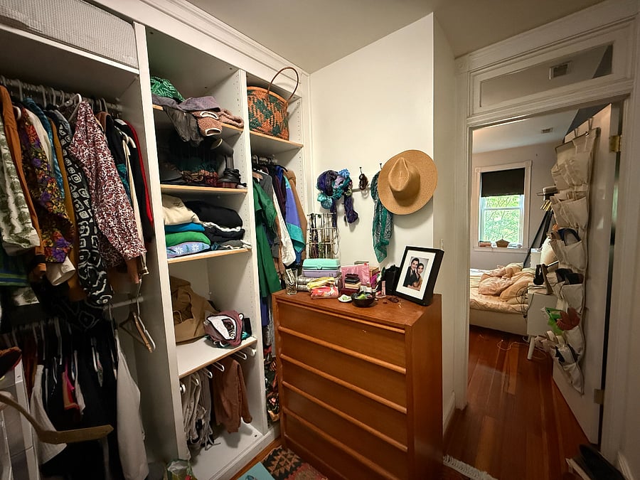 walk in closet between primary bedroom and kitchen