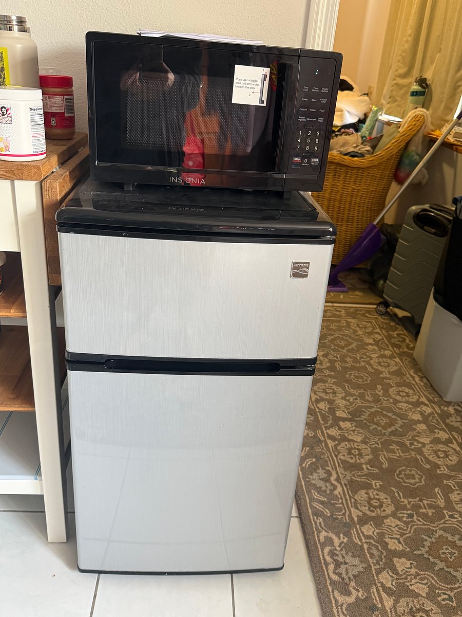 Mini refrigerator with new microwave oven and small utility table located in the private foyer