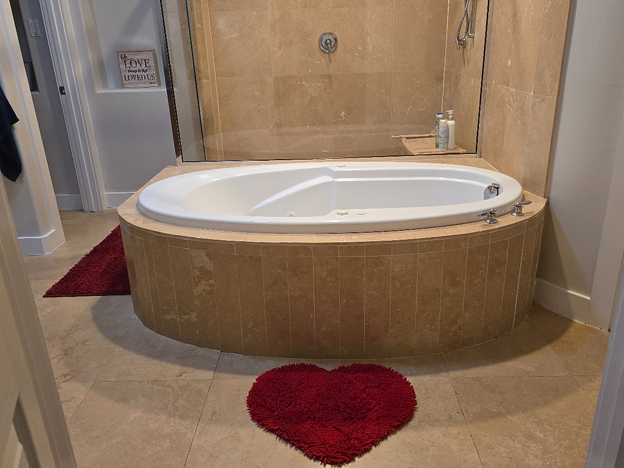 Private primary suite featuring a spacious bedroom with comfortable furnishings and a cozy seating area. The en-suite bathroom offers a relaxing soaking tub and separate walk-in shower, creating a perfect retreat for rest and relaxation.