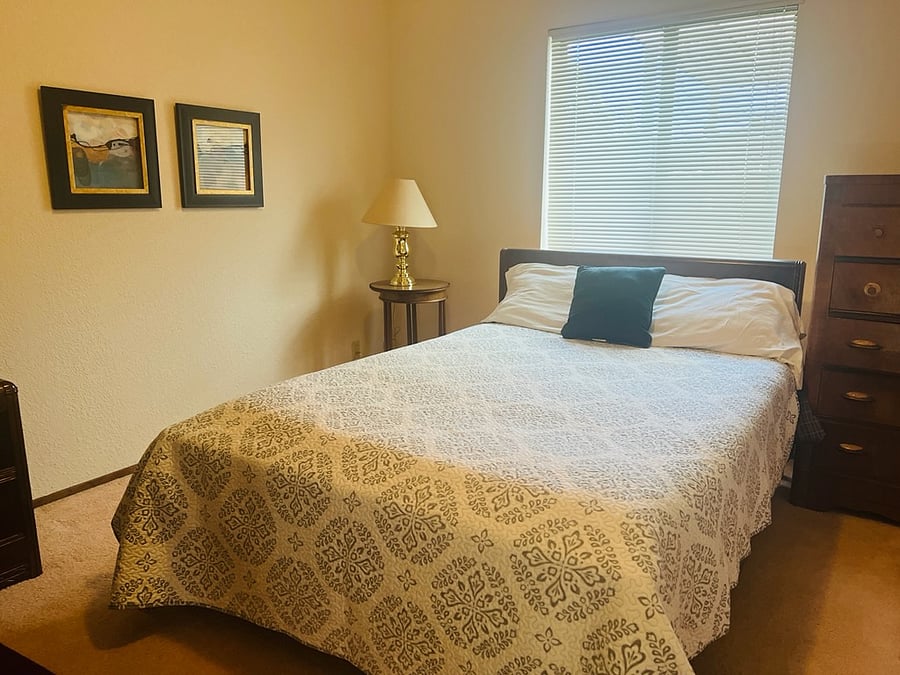 Bedroom B on Floor 1 with shared full hall bath near, with double bed, dresser and bureau, one night stand and lamp. 