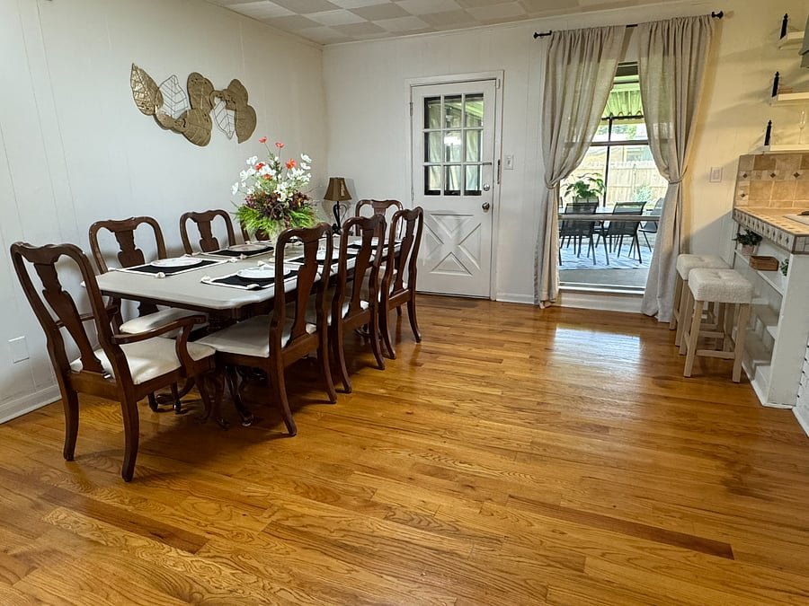 Large dining table with 8 chairs overlooking a screened-in patio