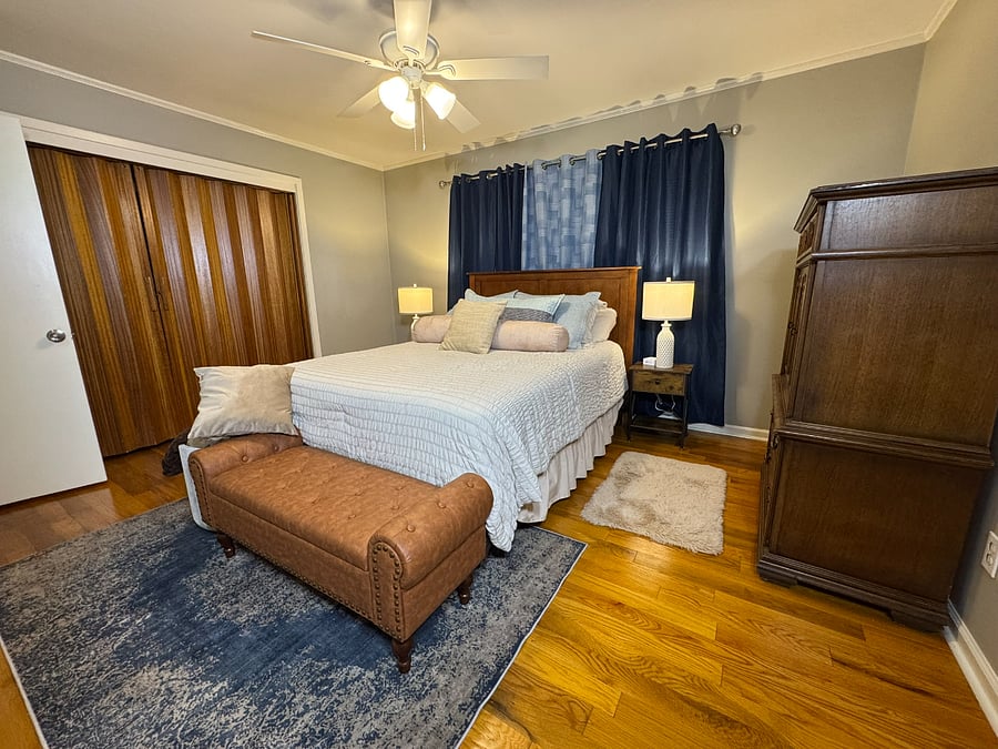 Primary bedroom has a queen-size bed with blackout curtains and a dedicated bathroom with shower