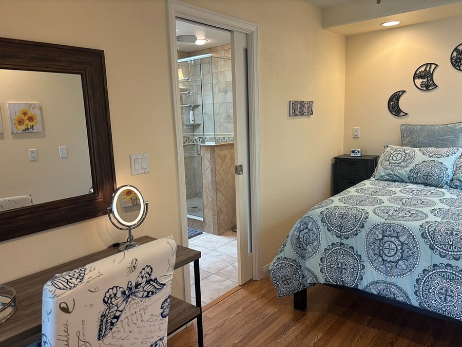 bedroom w/ bathroom entrance open (pocket door), vanity table w/ mirror & chair