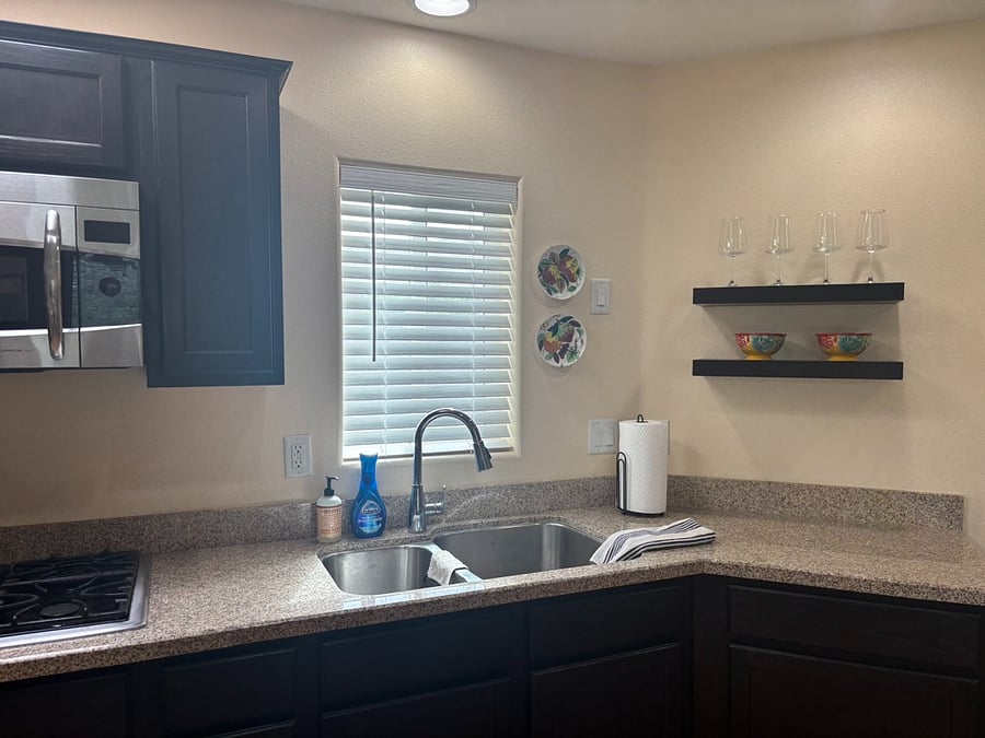 Kitchen - large double sink w/ garbage disposal, window, granite countertop, cabinet & shelf storage