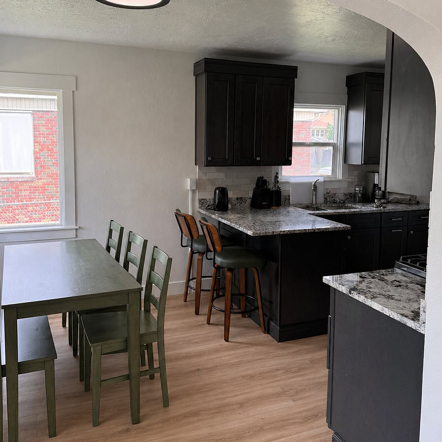 Spacious dining area featuring a full-size table with seating for fourideal for meals, remote work, or entertaining, with great natural light from nearby windows.
