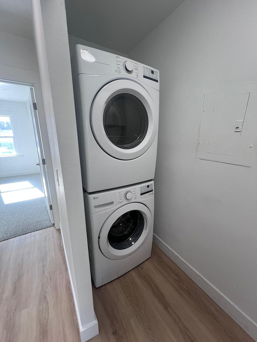 Private in-unit washer and dryer, complete with a well-stocked laundry setup including an iron, ironing board, and essentials for comfortable long-term stays.