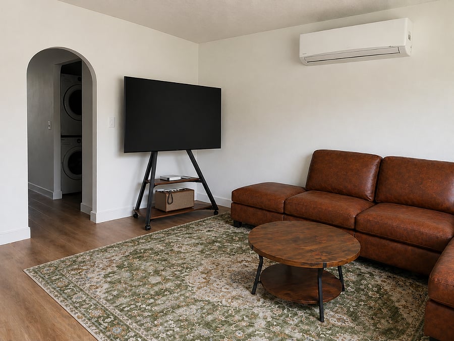 Comfortable living room featuring a large 55-inch Samsung Smart TV, cozy leather sectional, and stylish coffee table perfect for relaxing after a long day.