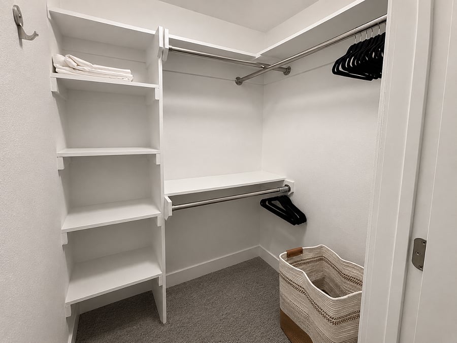 Spacious bedroom closet with built-in shelving and dual hanging rodsoffering plenty of storage for clothing and personal items.