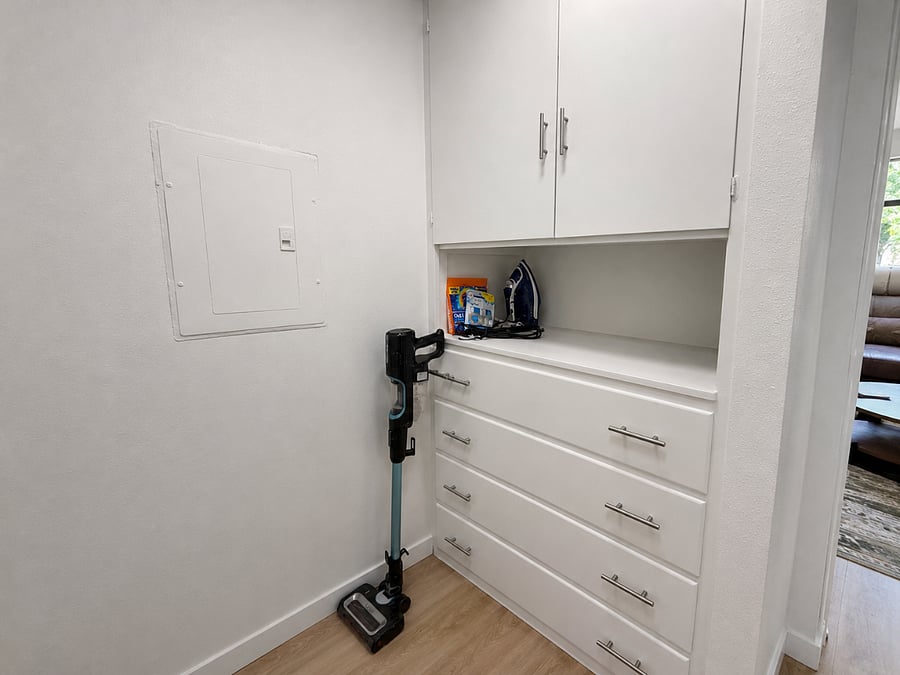 Additional storage in the laundry area with built-in cabinets and drawersperfect for keeping supplies and personal items organized. Includes an iron and ironing board for added convenience.