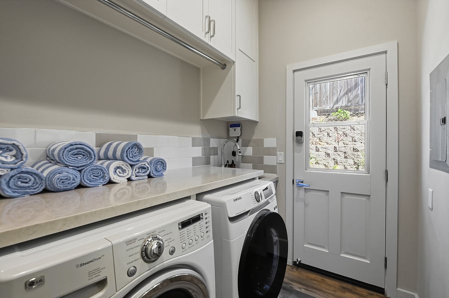 Dedicated laundry room with iron and ironing board