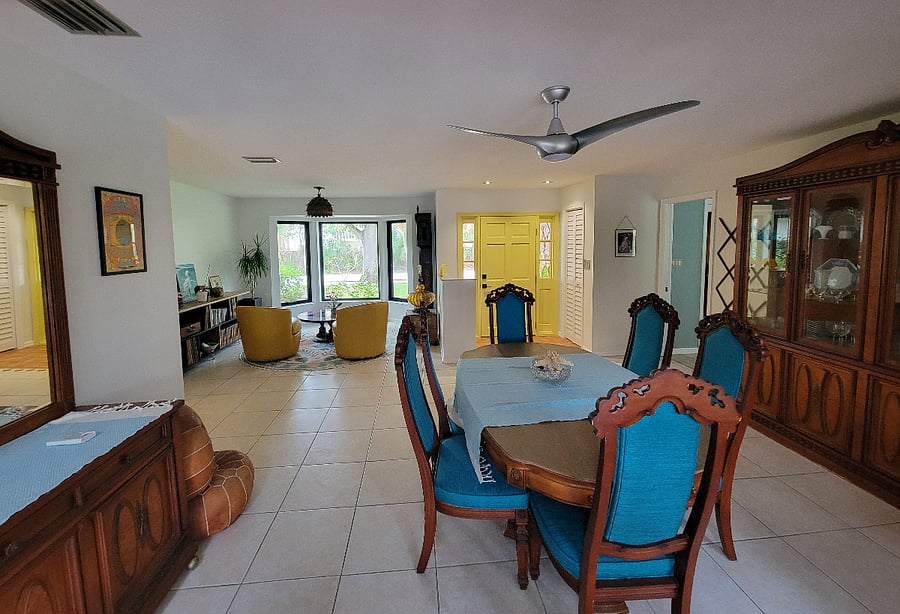 Dining room and sitting area with access to screened in porch and pool views