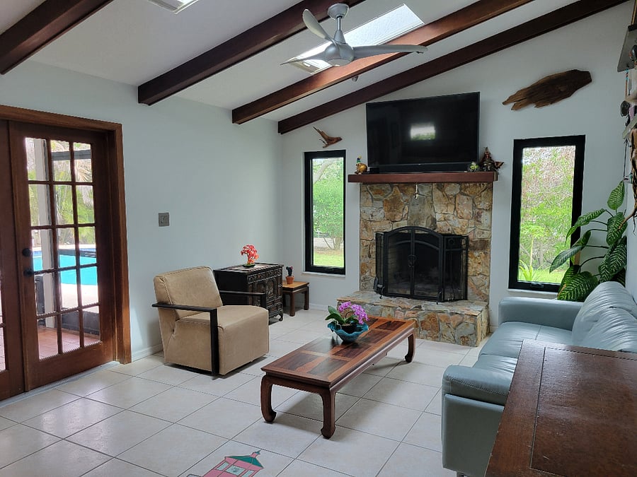 Living room with a wood burning fireplace and access to screened in porch