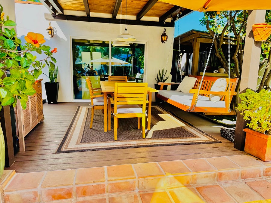 Gazebo patio off the detached studio with a dining table and a porch swing - perfect for lazy summer evenings!