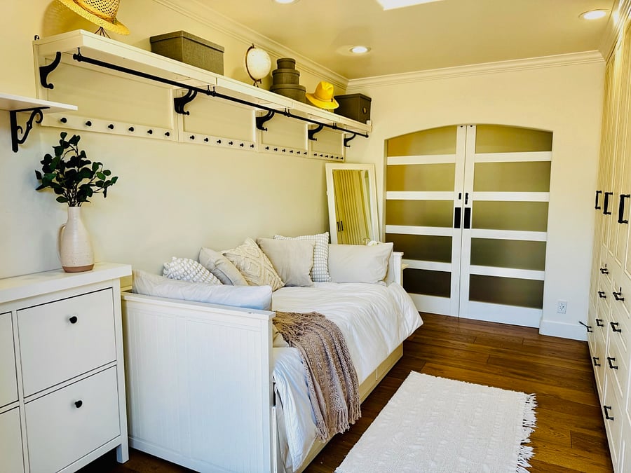 Guest Room 1 with twin daybed has tons of storage and French doors open out to the back patio. Bed tucks away to create a great reading nook, or pulls out to a queen for guests. Farmhouse door allows privacy.