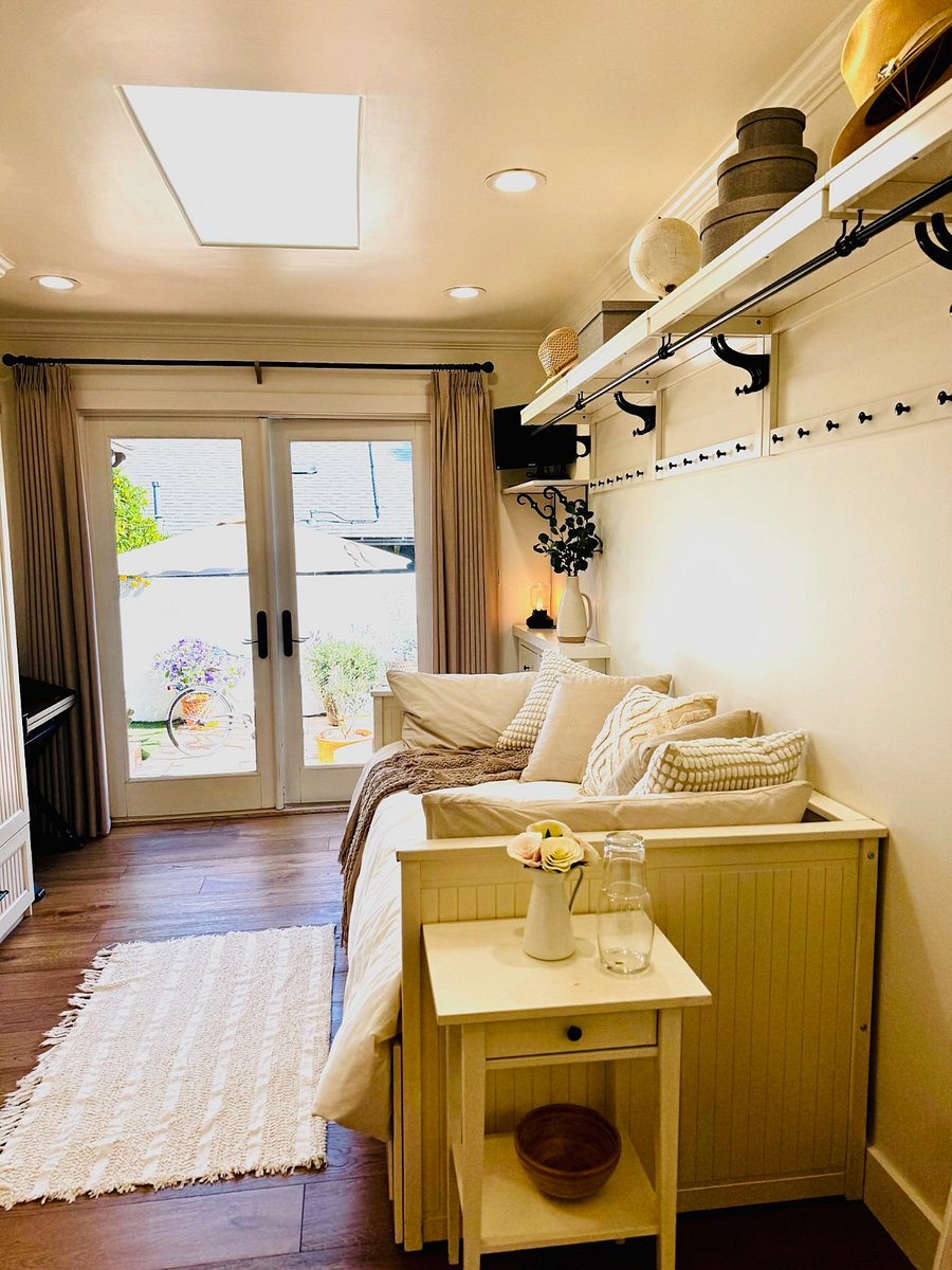 Guest Room 1 with twin daybed has tons of storage and French doors open out to the back patio. Bed tucks away to create a great reading nook, or pulls out to a queen for guests