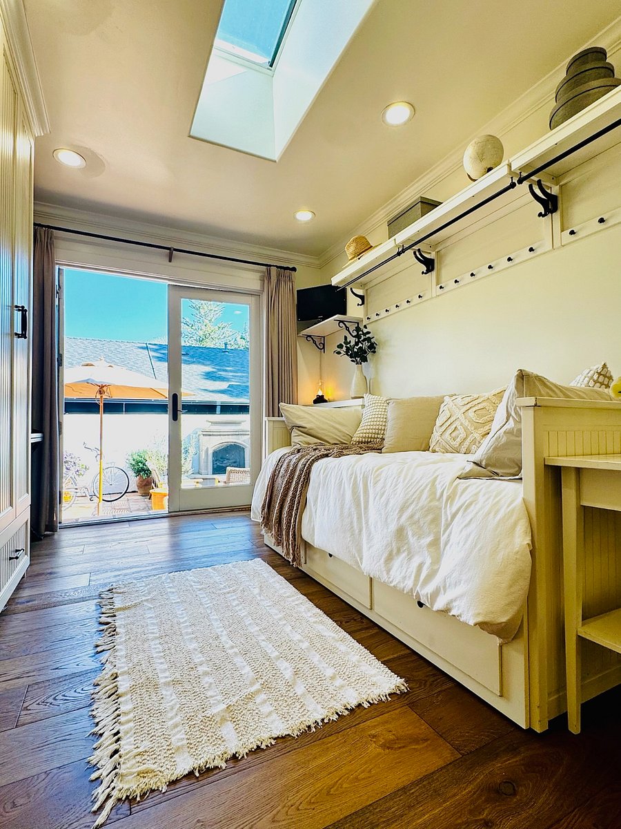 Guest Room 1 with twin daybed has tons of storage and French doors open out to the back patio. Bed tucks away to create a great reading nook, or pulls out to a queen for guests