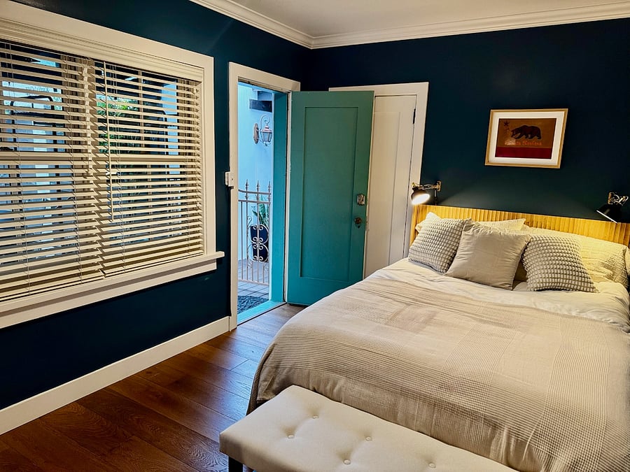 Guest bedroom 2 features a queen bed with desk and closet. Exterior access to kitchen patio and driveway.