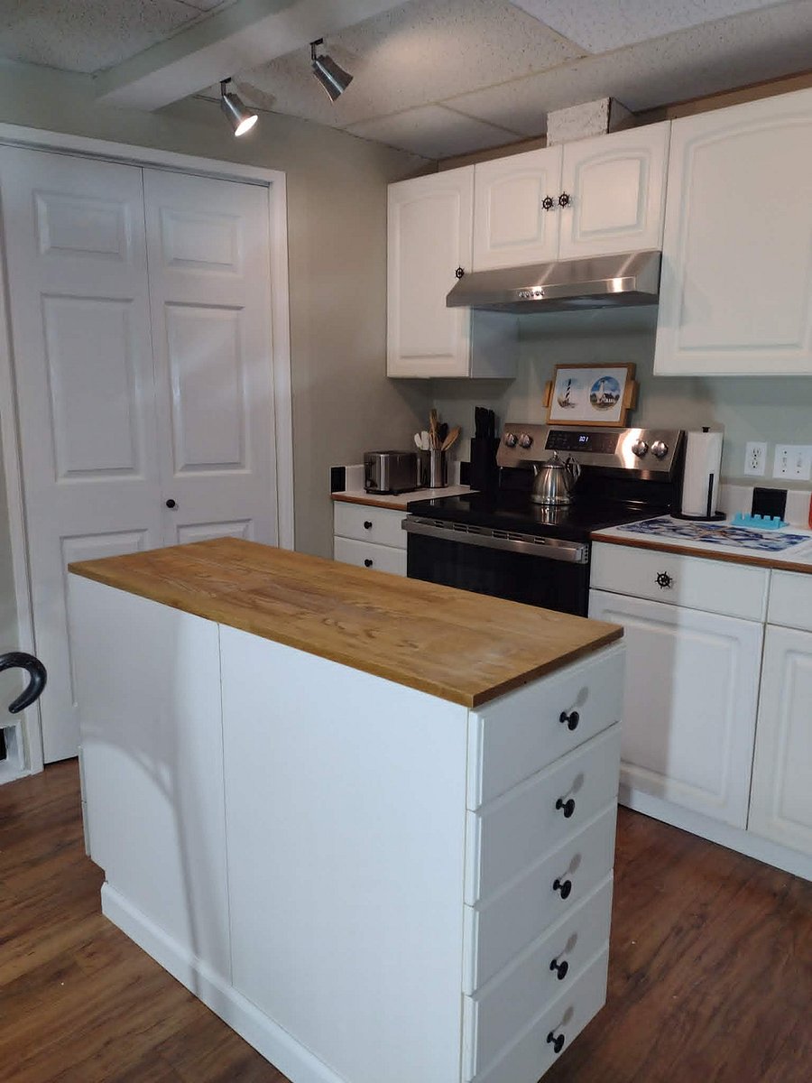 Kitchen with butcher block topped island.  Brand NEW appliances!  Stove, refrigerator, microwave and dual purpose coffee maker (can brew single cups or full pot)