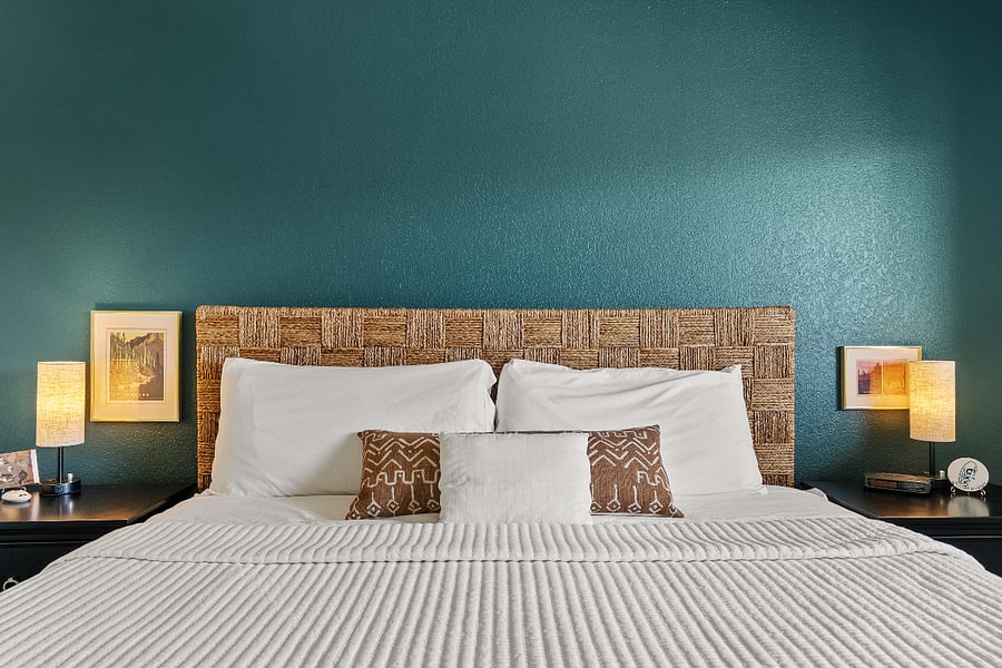 Comfortable king bed with soft linens, stylish accents, and a warm, inviting feel.
