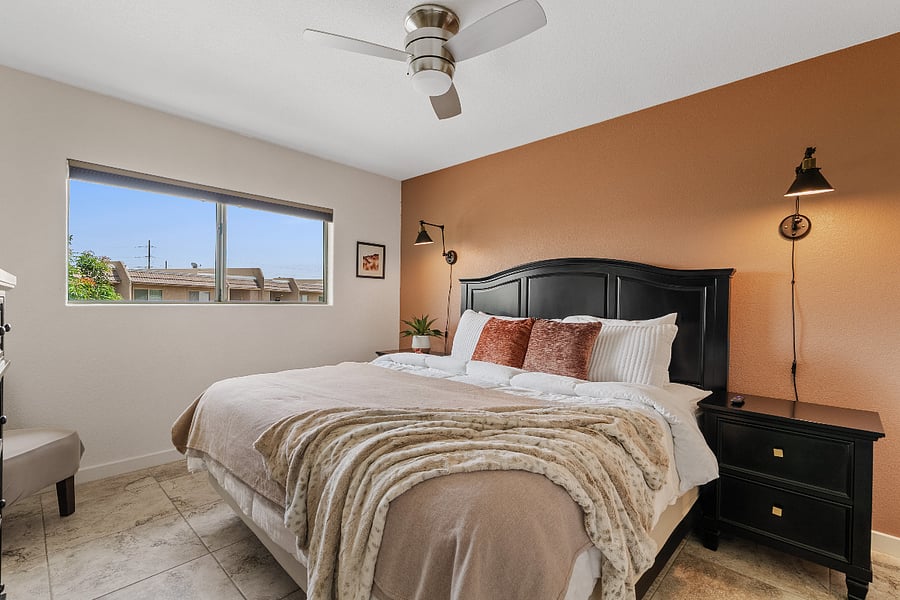 Primary Bedroom 1 offers a plush king bed, soft linens, a private ensuite bathroom, and a warm, inviting feel with peaceful water feature views.