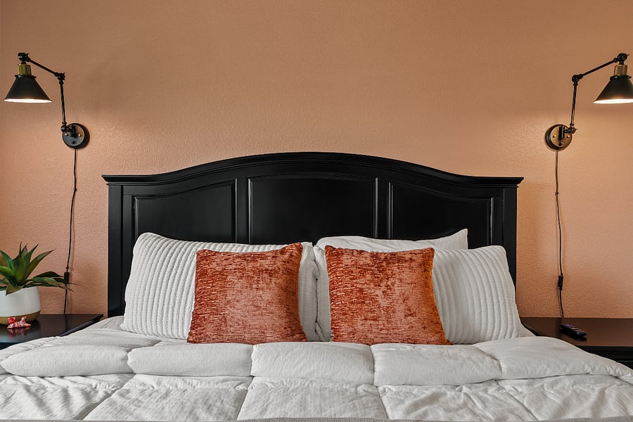 Bedroom 1 offers a plush king bed, soft linens, and a warm, inviting feel with peaceful water feature views.