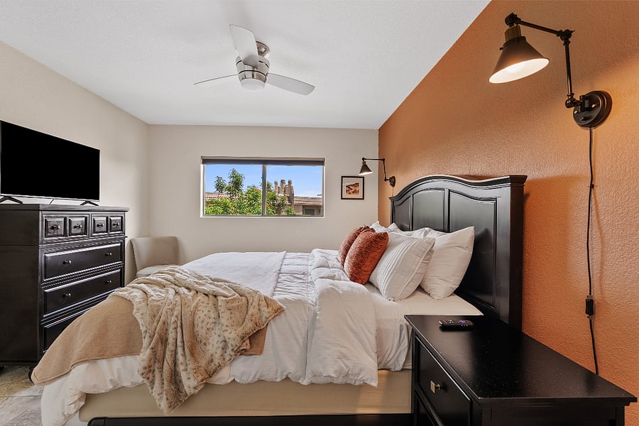  Primary Bedroom 1 offers a plush king bed, soft linens, and a warm, inviting feel with peaceful water feature views.