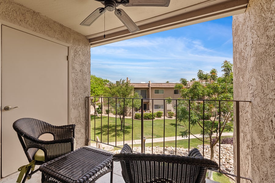 Private patio with comfortable seating and peaceful views of the landscaped community grounds.