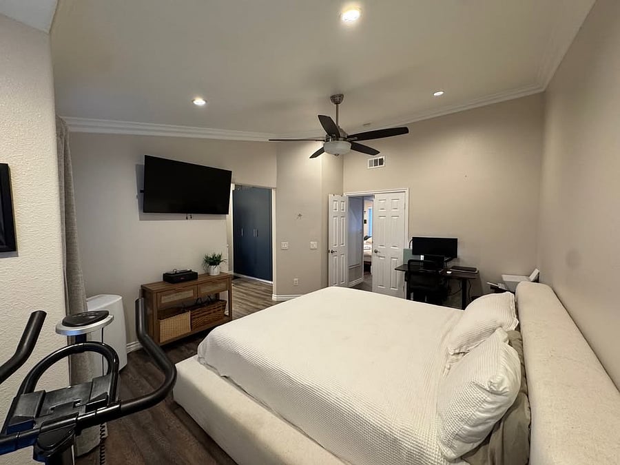 Primary suite with king bed, television, and dedicated working space