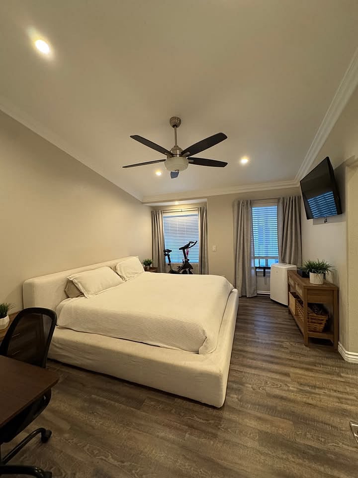 Primary suite with king bed, television, and dedicated working space