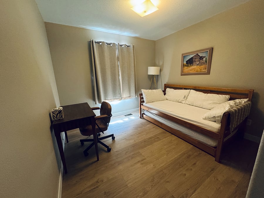 Second bedroom featuring twin day bed, additional pull out twin, and desk for work.