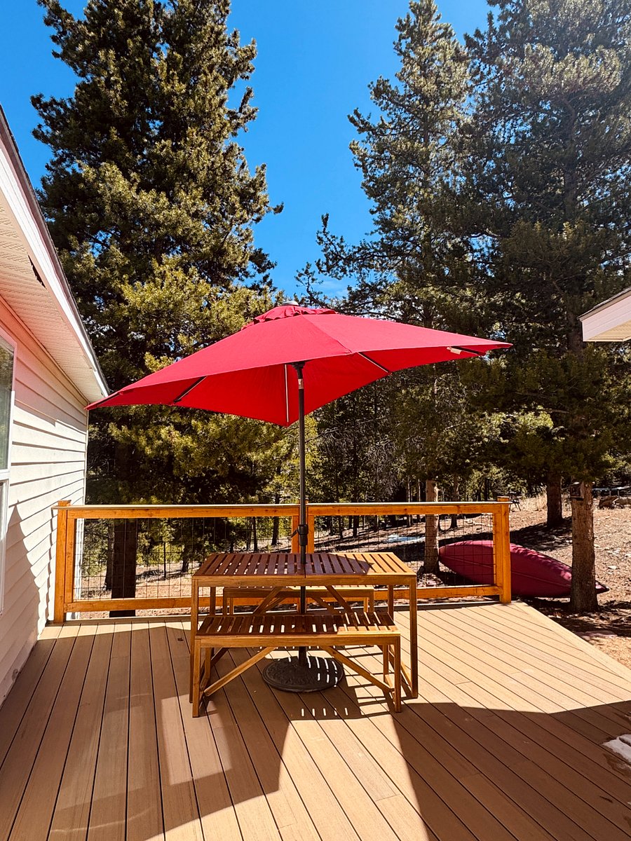 Private back deck with outdoor table and umbrella.