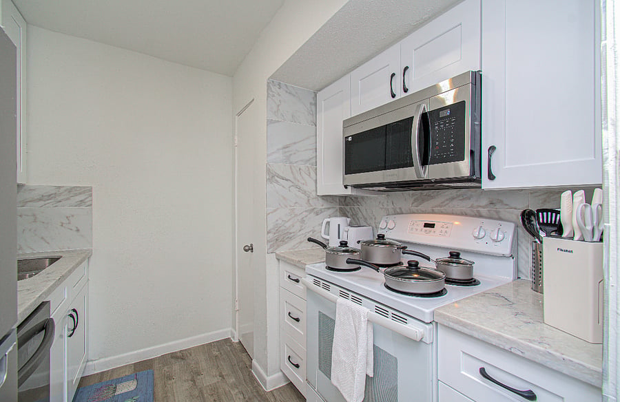 Newly renovated kitchen with quartz countertop, backsplash and shaker style cabinets