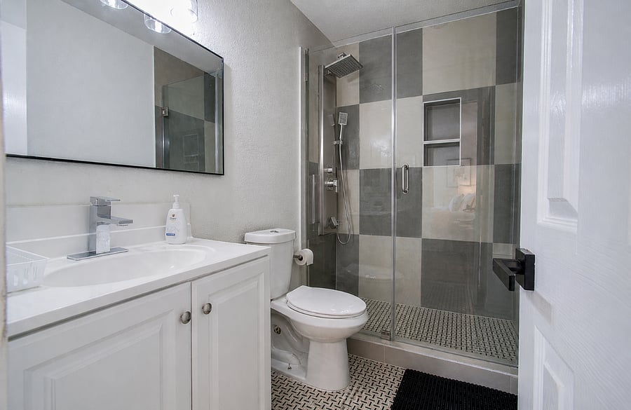 Ensuite bathroom with standing shower with rain shower head, medicine cabinet linen closet