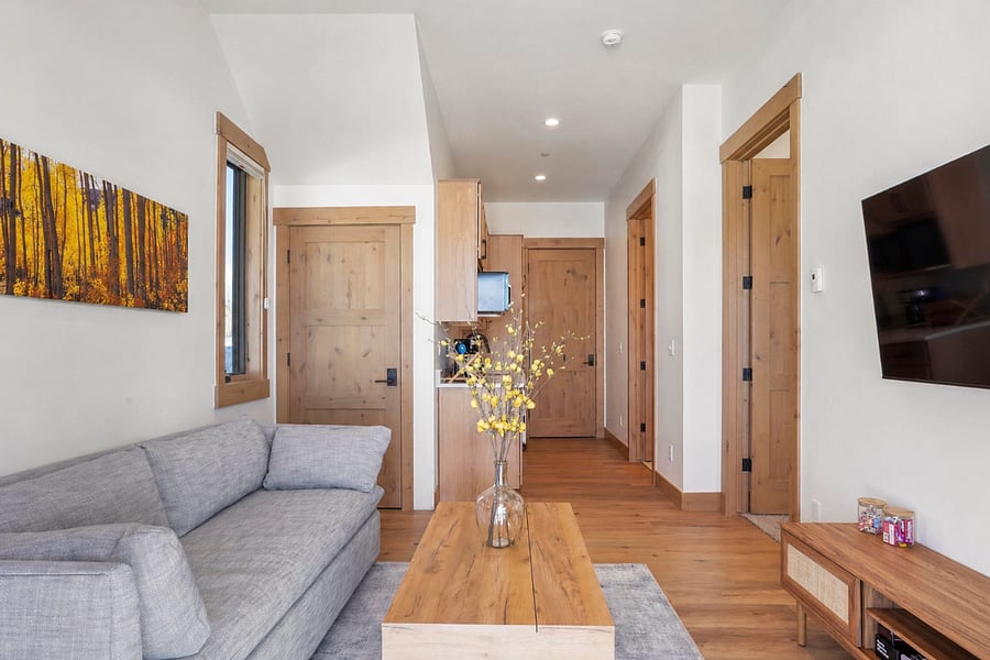 The living room was thoughtfully designed for flexible living. The coffee table lifts up to create a full worktop, and the C-shaped end tables are designed to pull around the couch  perfect as a side table, desk, or dining surface while you're seated. Everything you need without the clutter.