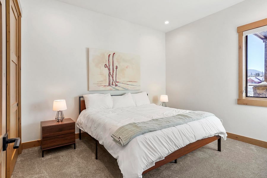 the bedroom features a room darkening shades, a king sized bed with linens & extra pillows included, and a large closet with a dresser and hangers provided.