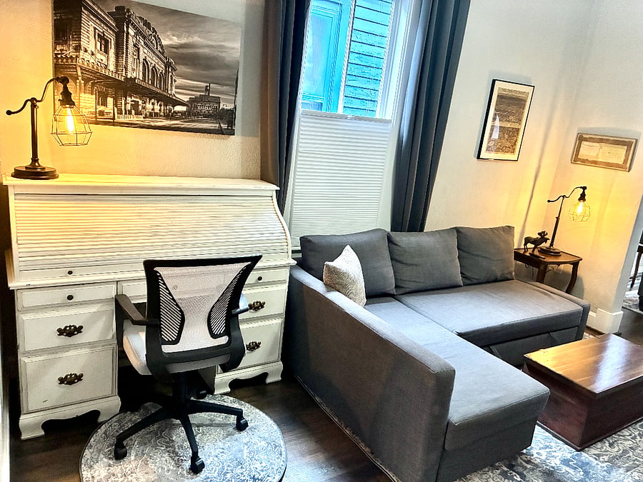 Living room includes a vintage roll top desk workspace.
