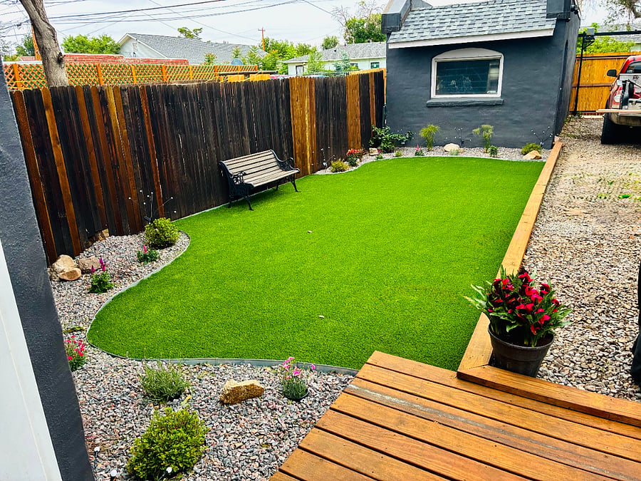 Fenced back yard with gated parking, patio, and BBQ.