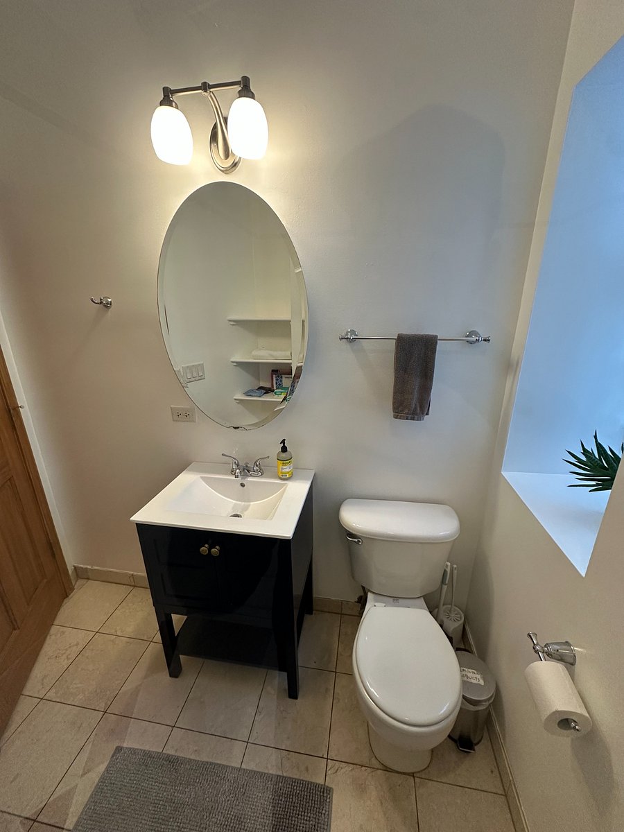 Clean, functional bathroom with vanity storage and bright natural light.