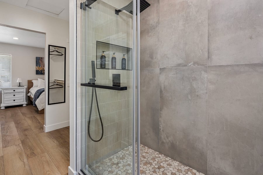 Spa-to-Suite Privacy: A view from the rain shower into the bedroom, featuring a custom barn door that allows you to easily close off your private sanctuary from the guest-access bathroom