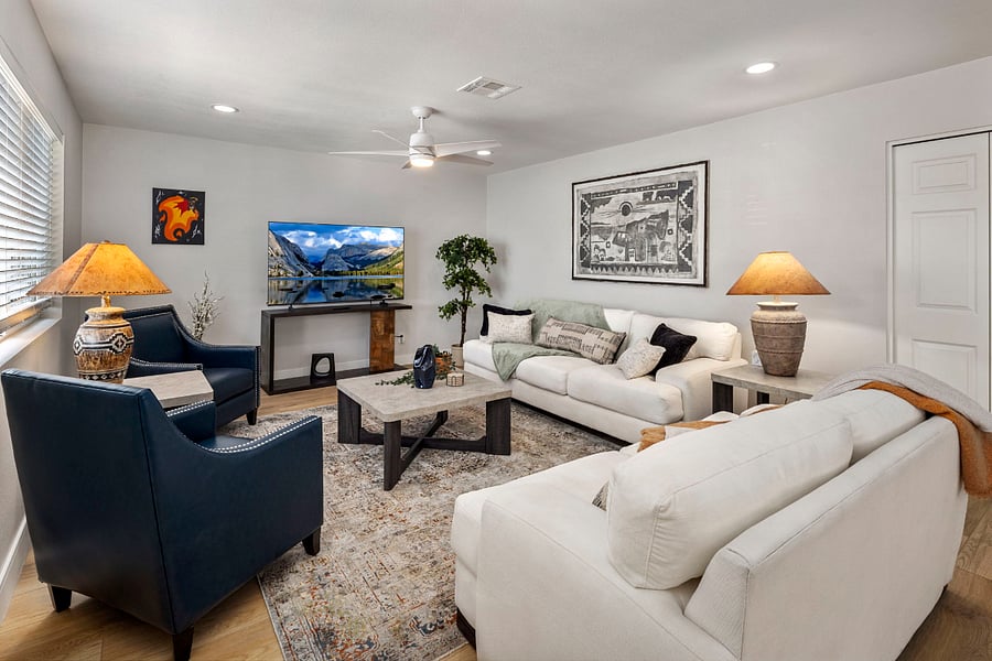 Modern Desert Luxe: Relax on oversized, ultra-comfy sofas and navy leather accents while enjoying the 65-inch Smart TV. Features warm Arizona-style lighting and open-concept flow to the kitchen