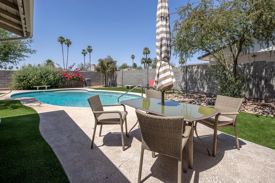 Private & Fully Fenced: A wide-angle view of the pool, lush garden, and outdoor dining area. Your own secluded resort in the heart of Tempe.